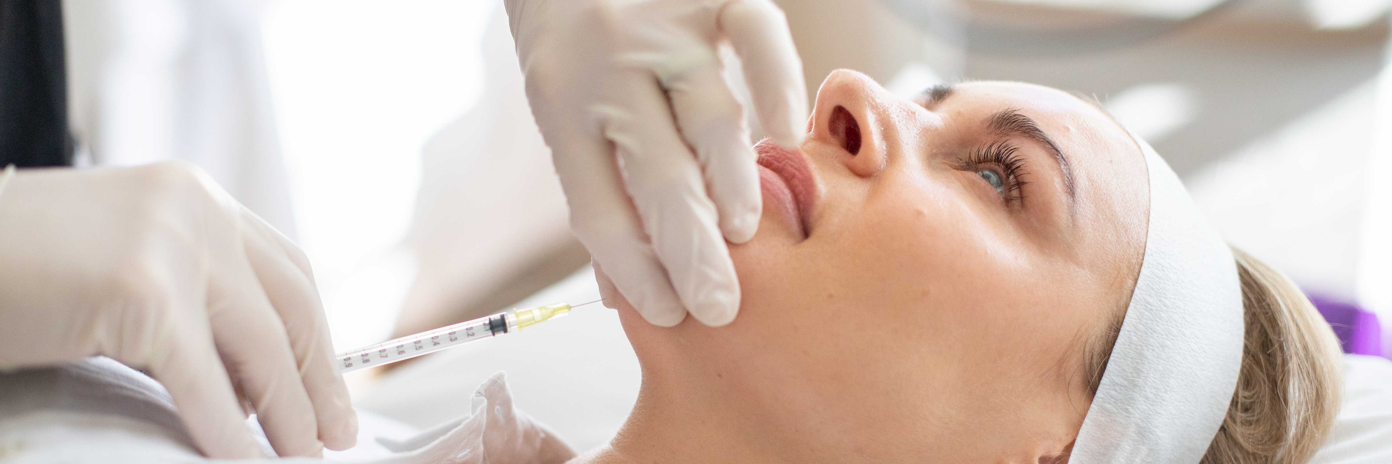 Woman receiving a double chin injection.